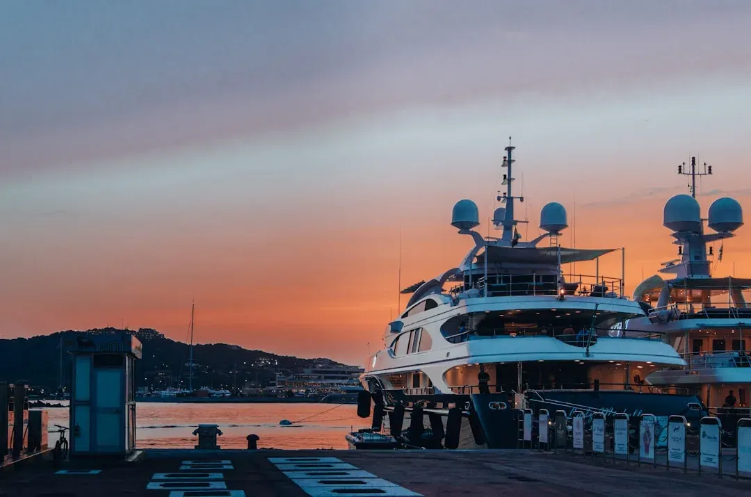 a yacht docked at a ferry terminal, with water in the background