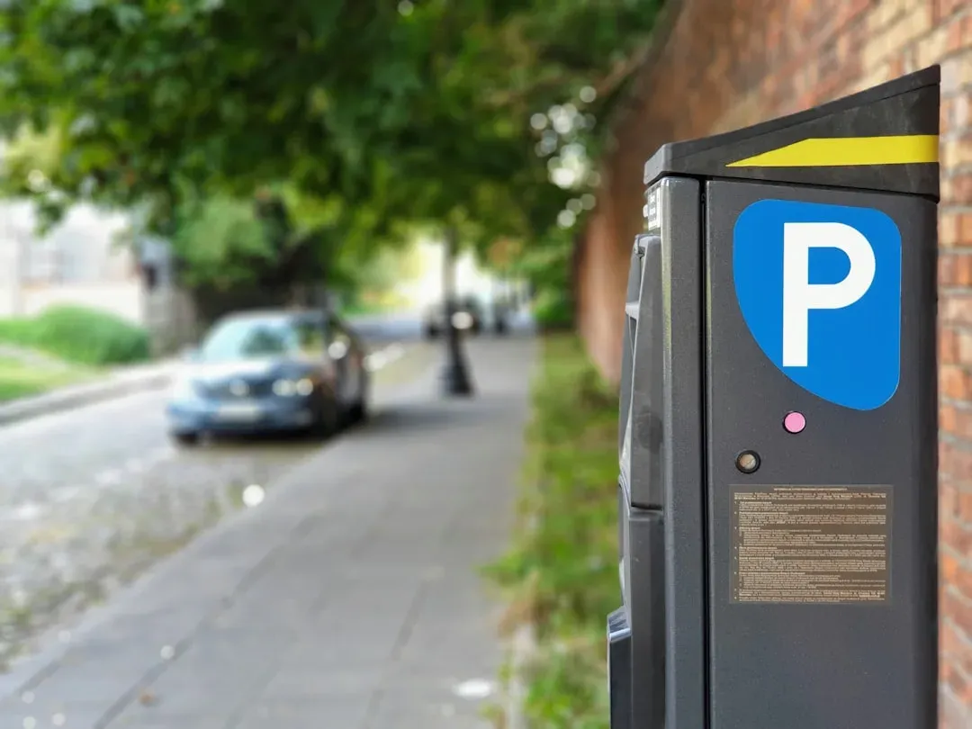 a parking meter or pay station on a street, with coins in the slot
